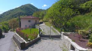 a house with a fence and a yard with flowers at Villa Il Circolo Bassone in Pontremoli
