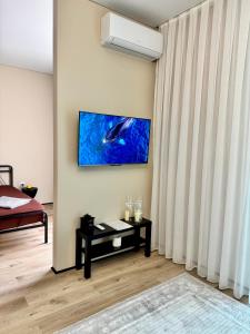 a living room with a fish painting on the wall at A-Six Apartment ЖК Достар in Karagandy