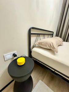a room with two beds and a table with a yellow lid at A-Six Apartment ЖК Достар in Karagandy