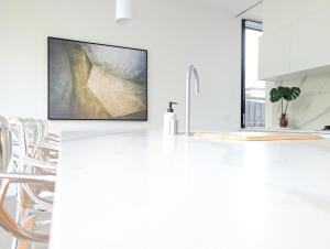 a kitchen with a white counter top with a tv at Donatella, Where Heritage Meets Haute Living in Bendigo +33 photos