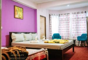 a bedroom with purple walls and a bed with ducks on it at Shenga Palace by truvalue hospitality in Jāmb