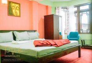 a bedroom with a bed and a blue chair at Shenga Palace by truvalue hospitality in Jāmb +1 photo