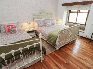 zwei Betten in einem Schlafzimmer mit Holzboden in der Unterkunft Bradshaw House in Castleton