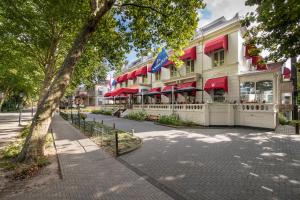 Un edificio con sombrillas rojas en una calle de la ciudad. en Bilderberg Grand Hotel Wientjes, en Zwolle