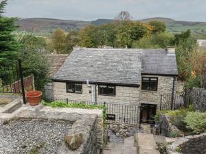 ein altes Steinhaus mit einem Zaun drum herum in der Unterkunft Bradshaw House in Castleton