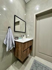 a bathroom with a sink and a mirror at A-Six Apartment ЖК Достар in Karagandy +22 photos