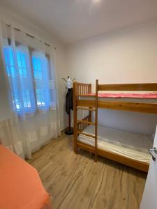 a bedroom with a bunk bed and two windows at Vila Blue River in Orikum
