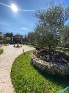 a stone wall with a fire pit in a park at Vila Blue River in Orikum