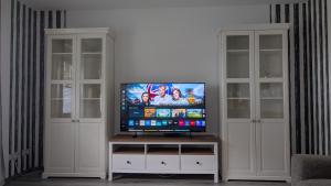 a flat screen tv sitting on top of a white entertainment center at " FeWo am Hof " Große Wohnung mit zwei Schlafzimmern, seperate Küche und großem Bad in Beverstedt