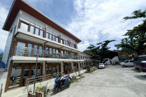 a building with a scooter parked in a parking lot at Sebay Surf Central San Juan La Union in San Juan