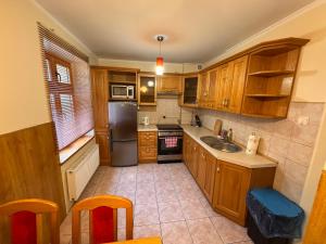 a kitchen with wooden cabinets and a stainless steel refrigerator at Leśny apartament Woziwoda in Legbąd