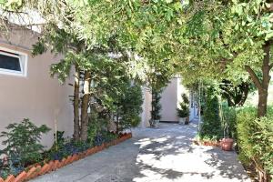 a walkway in a garden with trees and plants at Aky apartment in Škaljari