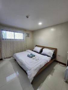 a bedroom with a large bed and a window at Pacific Paradise Guesthouse in Ubay
