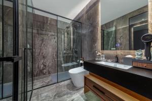 a bathroom with a shower and a toilet and a sink at Floral Hotel in Datong +9 photos