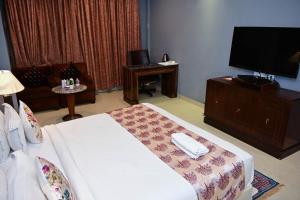 a bedroom with a bed and a flat screen tv at Airport Hotel Port View,Complimentary Airport Pickup or Drop in New Delhi