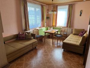 a living room with a couch and a table and chairs at Amstetter’s Ferienwohnung in Waldenstein