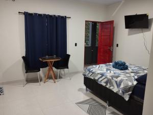 een slaapkamer met een bed en een tafel en een rode deur bij Comfortable studio, well located in Macapá +4 foto's