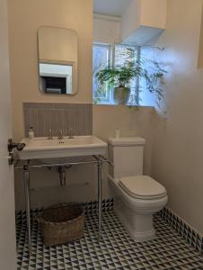 Un baño con inodoro, lavabo y espejo. en Accommodation in Dorset, Sherborne, en Sherborne