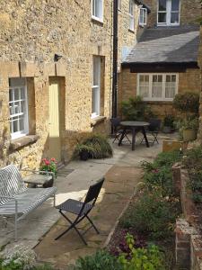Un patio con sillas y una mesa frente a un edificio. en Accommodation in Dorset, Sherborne, en Sherborne