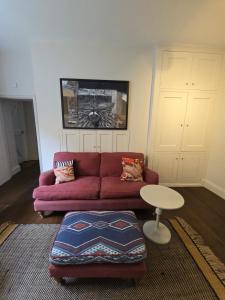 a living room with a red couch and a table at Accommodation in Dorset, Sherborne in Sherborne
