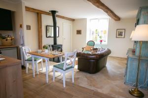 sala de estar con sofá, mesa y fogones en Aux Roses et aux Poutres, en Le Tremblay-le-Vicomte