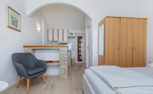 a bedroom with a bed and a chair and a fireplace at Villa Marevista in Lokva Rogoznica +61 photos