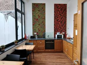 a kitchen with wooden cabinets and a table with chairs at La porte in Huy