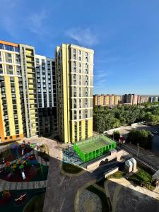 a view of two tall buildings with a playground at A-Six Apartment ЖК Достар in Karagandy