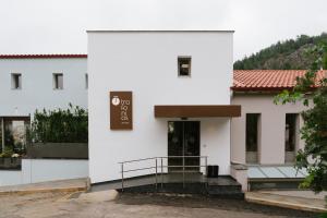 a white building with a sign on the door at Trofonios Boutique Hotel in Levádeia