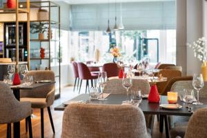ein Restaurant mit Tischen und Stühlen und Weingläsern in der Unterkunft Bilderberg Grand Hotel Wientjes in Zwolle