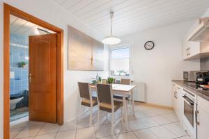 a kitchen with a table and chairs and a clock at Cosmic Living by Tayo Ajayi in Zwickau