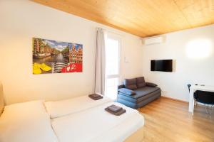 a living room with a white couch and a chair at 211 Amsterdam, Studio Apartment, 30m2 1-4 Pers in Klagenfurt