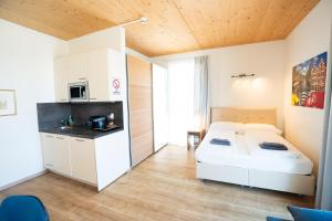 a bedroom with two beds and a kitchen with a microwave at 211 Amsterdam, Studio Apartment, 30m2 1-4 Pers in Klagenfurt