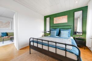 a bedroom with a bed with a green wall at Cosmic Living by Tayo Ajayi in Zwickau