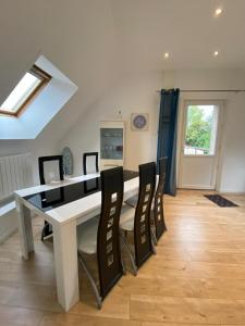 a dining room with a white table and chairs at Au bonheur des Anes - Gite Maya in Le Quesnoy-en-Santerre