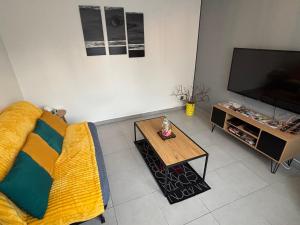 a living room with a couch and a coffee table at Maison de ville Chauny in Chauny