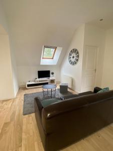 a living room with a couch and a table at Au bonheur des Anes - Gite Maya in Le Quesnoy-en-Santerre +3 photos