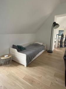 a bedroom with a white bed and a lamp at Au bonheur des Anes - Gite Maya in Le Quesnoy-en-Santerre