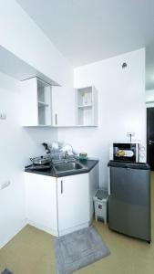 a white kitchen with a sink and a microwave at Modern Comfort Studio with City Views in Molo +2 photos