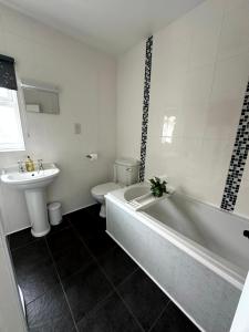 une salle de bain avec une baignoire, un lavabo et des toilettes dans l'établissement Oxwich View Cottage, à Swansea 27 autres photos
