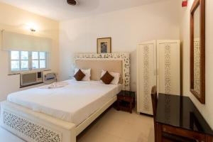 a bedroom with a white bed and a window at 2BHK Apartment 2mins to beach Candolim in Candolim