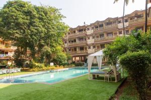 a hotel with a swimming pool in front of a building at 2BHK Apartment 2mins to beach Candolim in Candolim