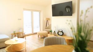 a living room with a couch and a tv on the wall at Petříkovy Apartmány in Bulhary