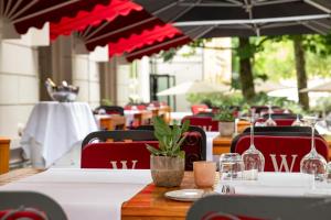ein Tisch in einem Restaurant mit roten Stühlen und einer Pflanze in der Unterkunft Bilderberg Grand Hotel Wientjes in Zwolle + 33 Fotos