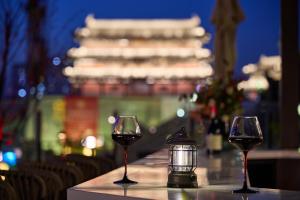a table with two glasses of wine and a lantern at Floral Hotel in Datong