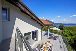 a house with a balcony with chairs and a view of the water at Villa Spa Nipotine in Cissano
