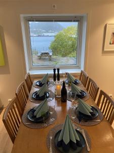 Una mesa de comedor con sillas y una gran ventana. en Modern apartment with mountain and sea view, en Svolvær