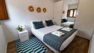 ein kleines Schlafzimmer mit 2 Betten und einem Spiegel in der Unterkunft Casa Rosa, Quinta Carmo - Alcobaça/Nazaré in Alcobaça + 25 Fotos