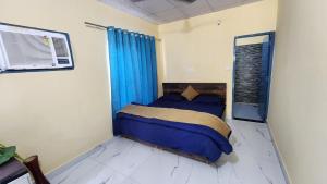 a bedroom with a bed with blue sheets and a window at Saanjh Farm in Gurgaon +15 photos