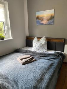 a bedroom with a bed with a blanket and pillows at Zum Kölpiensee in Kolpinsee